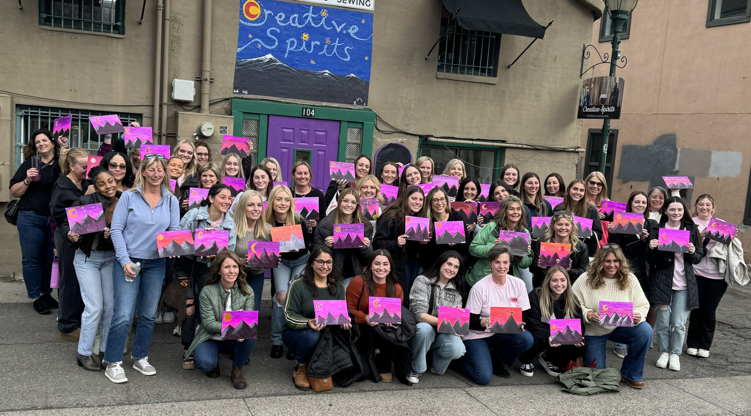 A group of people holding pink signs in front of a building. A group of people holding pink signs in front of a building.